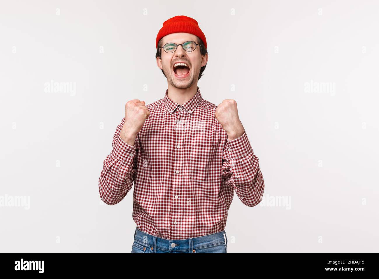 Portrait du jeune homme joyeux et joyeux a mis le pari et gagner le prix, l'enracinement pour l'équipe de regarder le match de sport, l'yelling triomphant et la pompe de poing comme célébrant Banque D'Images