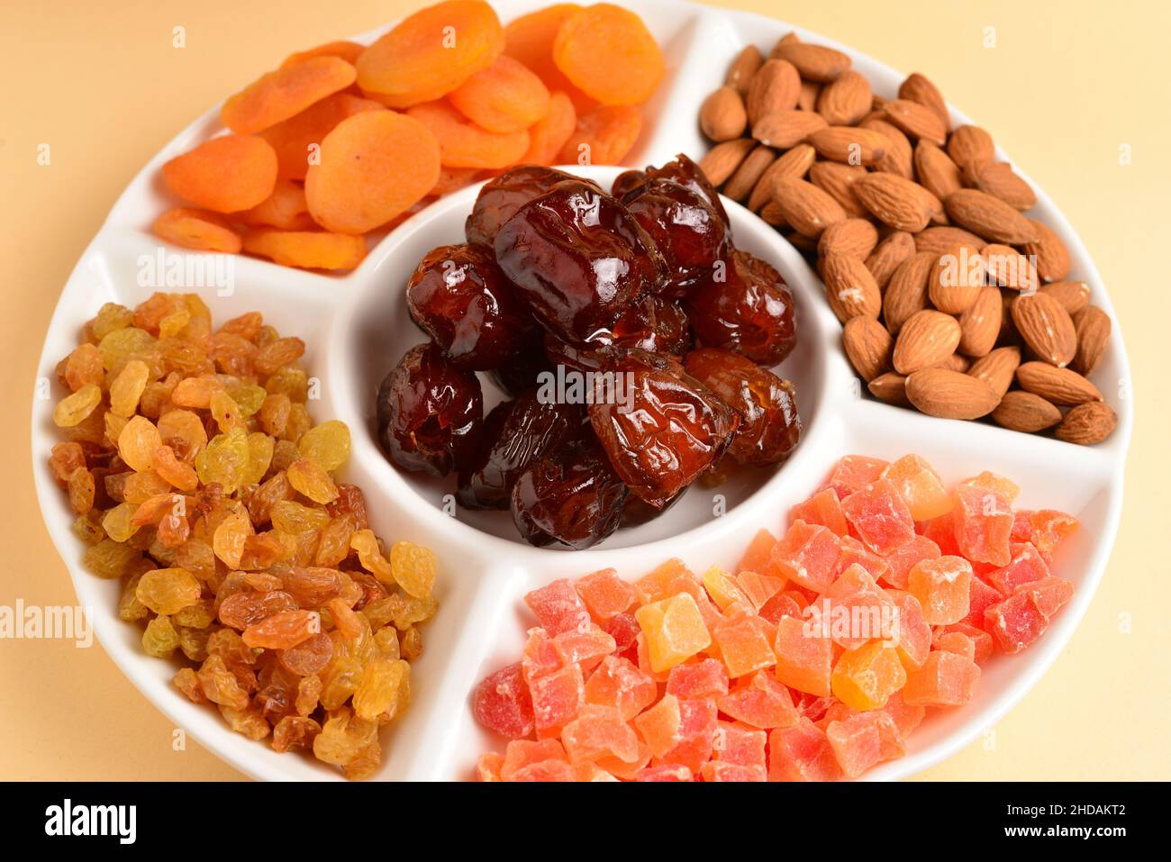 Mélange de fruits secs et de noix sur une assiette blanche.Abricot, amande,  raisin, datte les fruits.Sur fond beige.Espace pour le texte ou la  conception Photo Stock - Alamy