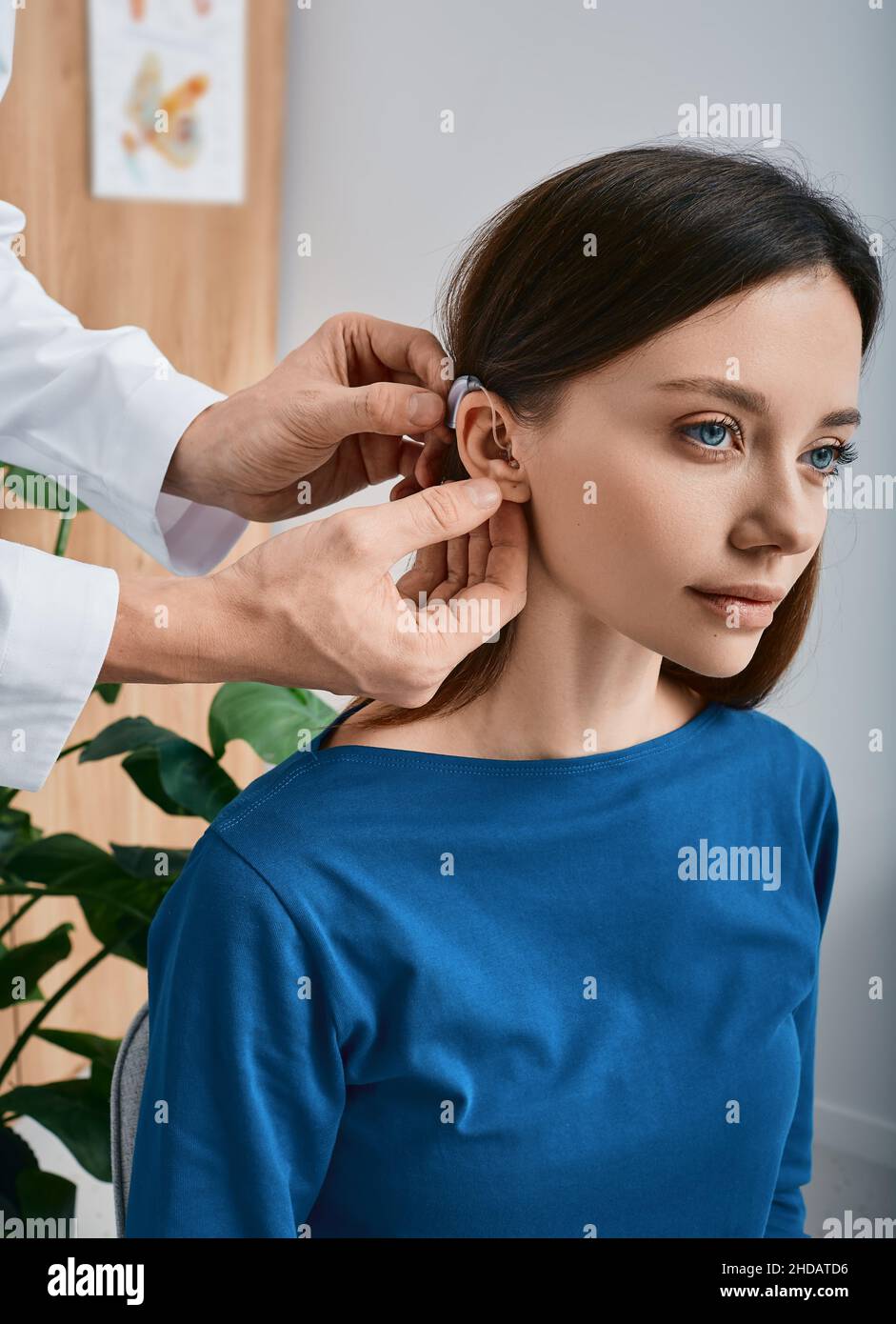 Femme caucasienne pendant l'installation prothèse auditive dans son oreille par son audiologiste, gros plan.Traitement auditif pour les personnes malentendantes Banque D'Images