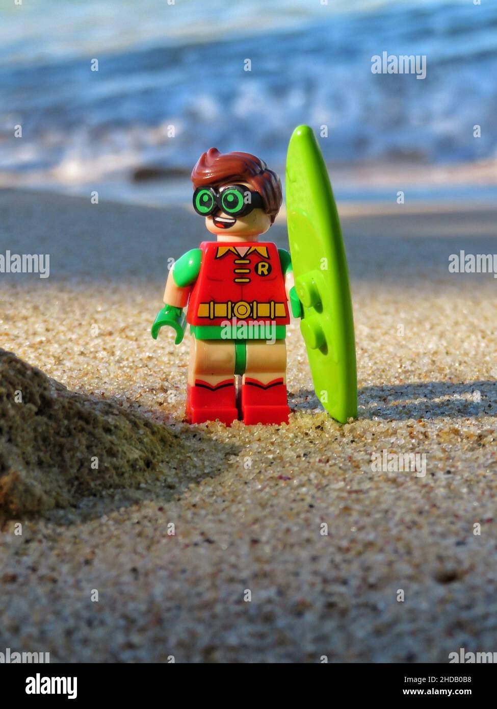 Photo verticale d'un jouet Lego tenant une planche de surf près de la plage  Photo Stock - Alamy