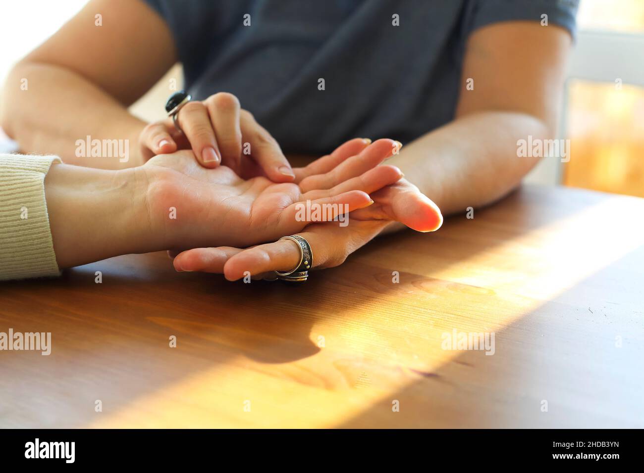 Session de Chiromancy.Femme rendant visite à un expert palmistère, photo rognée.Fortune Teller regardant la main femelle, la lecture de l'avenir, l'analyse des lignes de vie sur la paume Banque D'Images