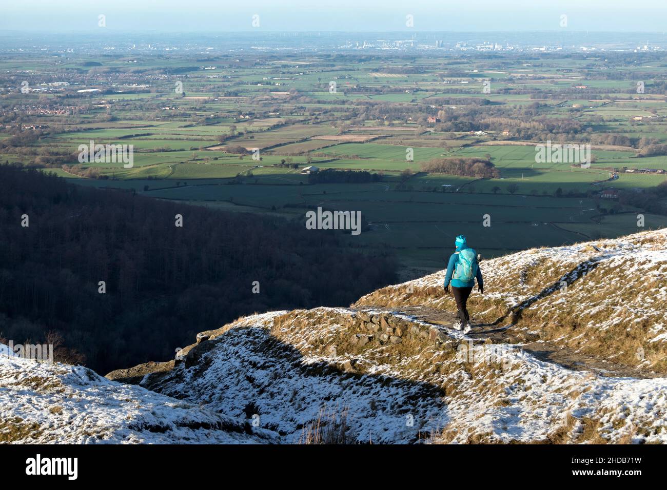 Walker sur Cleveland Way à Urra Moor en hiver avec la vue vers Teesside, parc national de North Yorkshire Moors, Royaume-Uni Banque D'Images