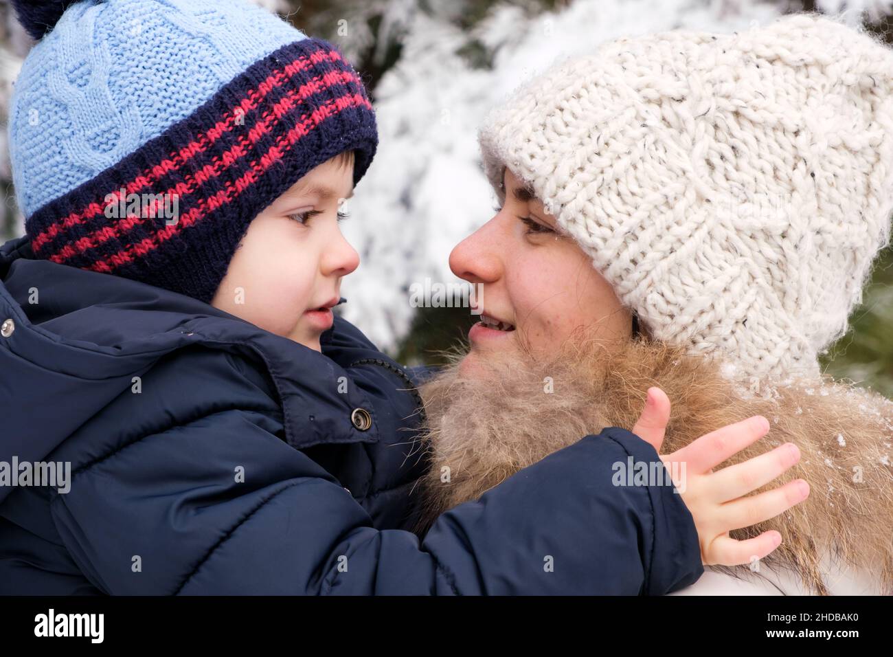 Mère et fils se regardent dans la forêt d'hiver, passe-temps en famille, vacances Banque D'Images