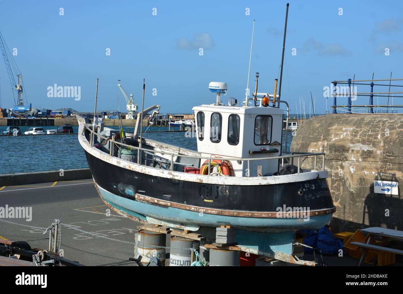 Un petit bateau de pêche en cours de réparation sur le côté du port de St Peter Port, Guernesey, une dépendance de la couronne britannique dans les îles Anglo-Normandes. Banque D'Images