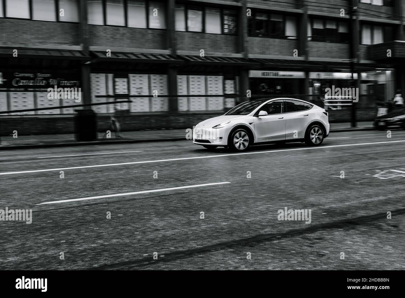 Tesla modèle S noir et blanc en voiture à Vancouver sur une rue calme, humide et grungy Banque D'Images