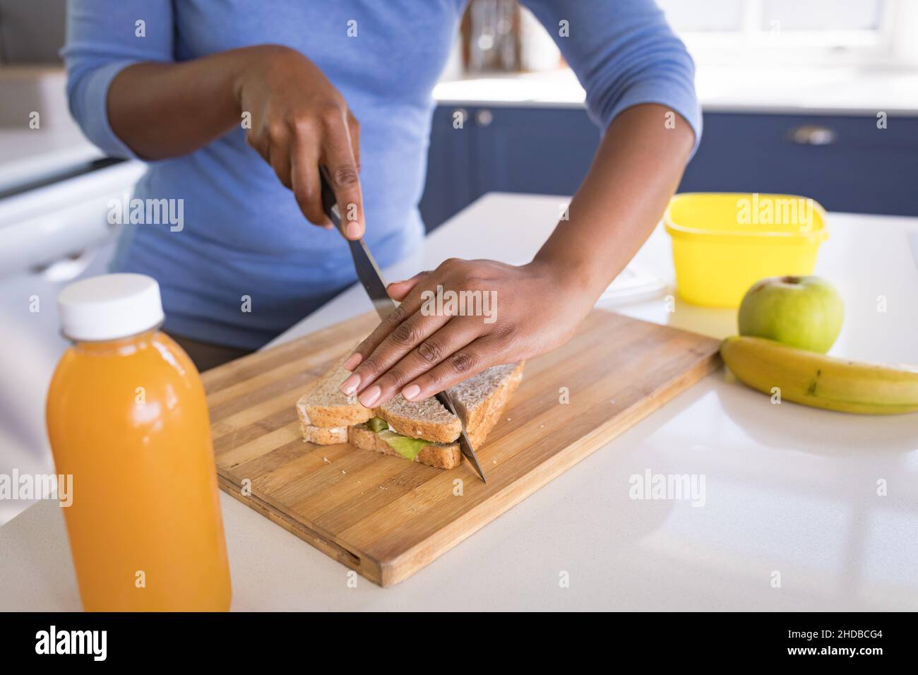 Mi-section d'une adolescente préparant un sandwich à l'île de cuisine Banque D'Images