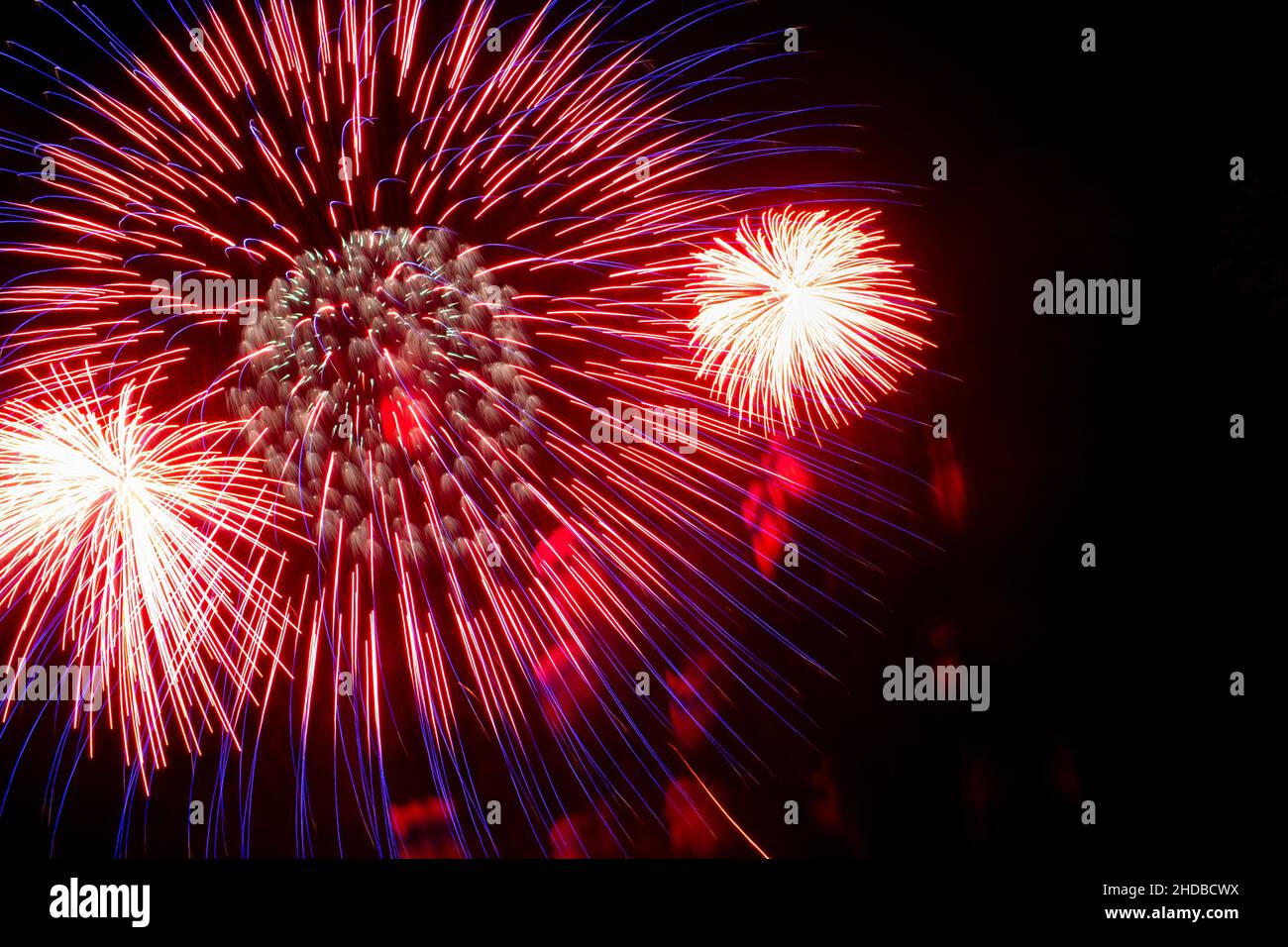 Feu d'artifice rouge et blanc sur fond ciel noir.Concept de vacances.Gros plan Banque D'Images