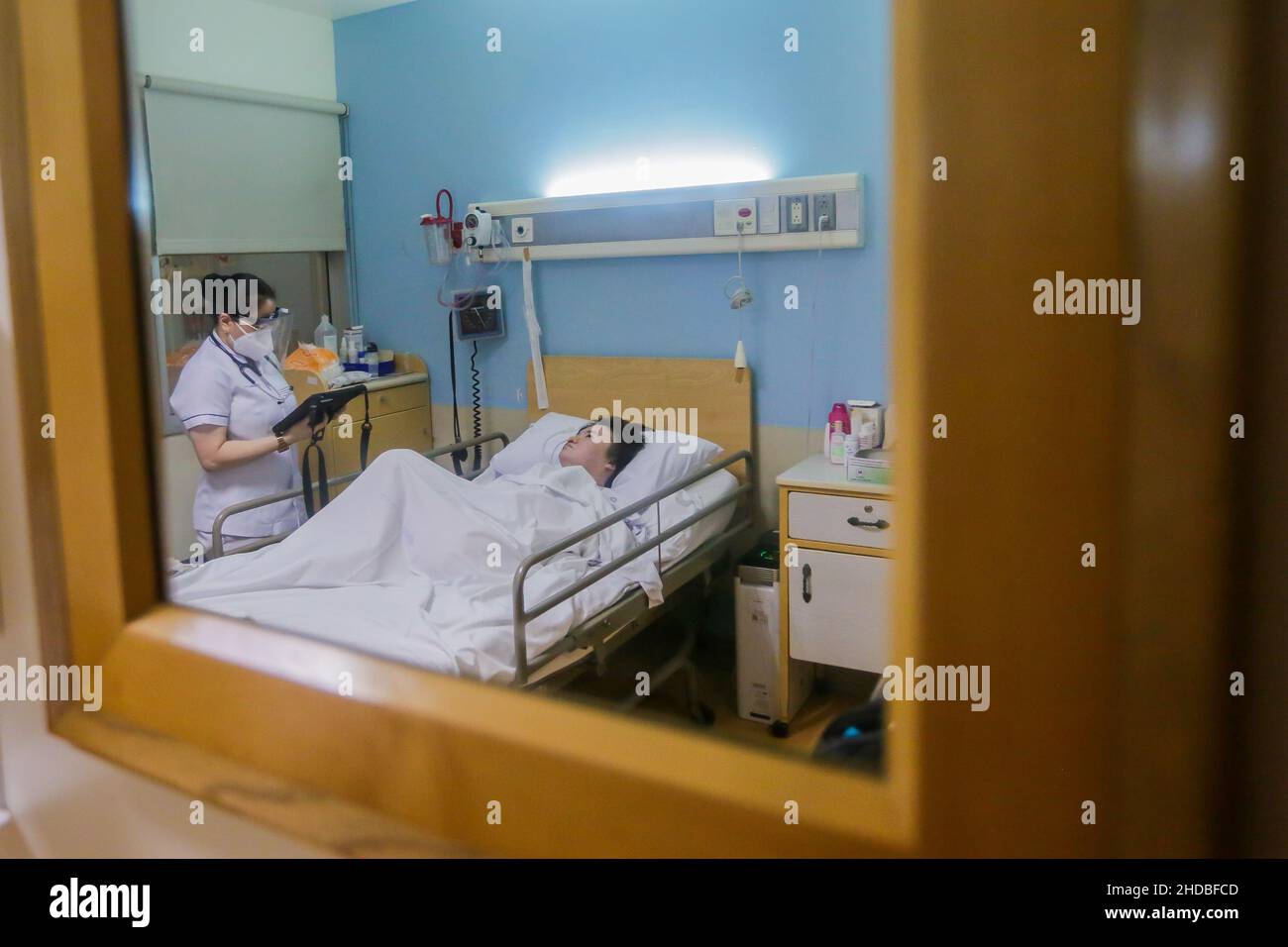 (220105) -- PASIG CITY, 5 janv. 2022 (Xinhua) -- Li Jinxin, une chinoise de 26 ans, est vue dans un miroir comme elle est fréquentée par son infirmière Sherricka Mae Navalta dans sa chambre à l'hôpital de la ville médicale de Pasig City, aux Philippines, le 13 décembre 2021.Li Jinxin a trouvé son rêve de rentrer à la maison devenu réalité après avoir lutté contre une maladie dévastatrice pendant près de deux ans et demi aux Philippines qui a presque coûté la vie.Li a passé 904 jours dans Medical City en raison d'une hémorragie cérébrale.POUR ALLER AVEC 'Feature: Avec l'aide de médecins philippins, une fois critique-malade chinois woma Banque D'Images