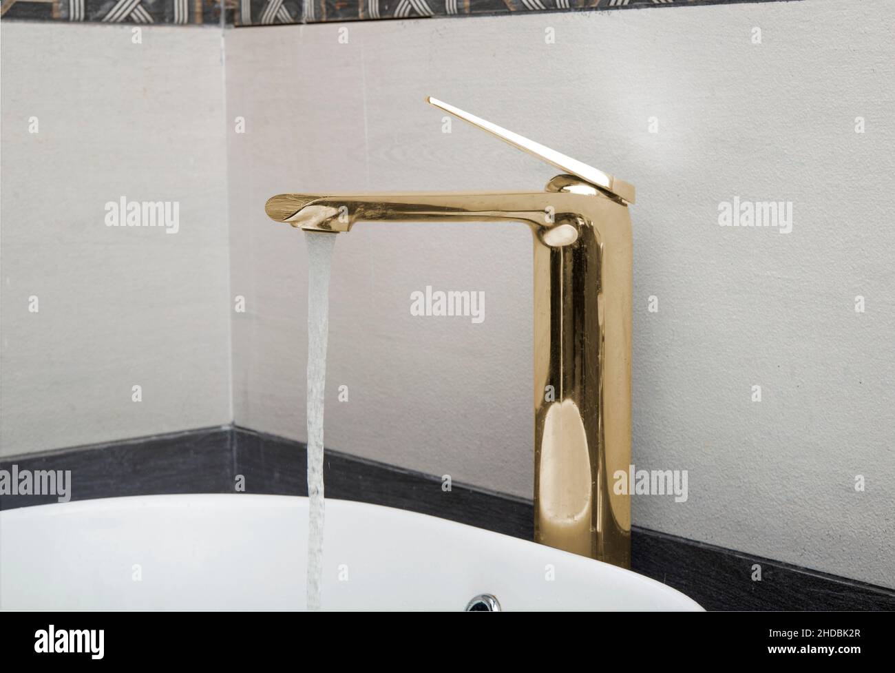 Meuble-lavabo de couleur dorée, robinet d'eau, vue rapprochée avec eau courante. Banque D'Images