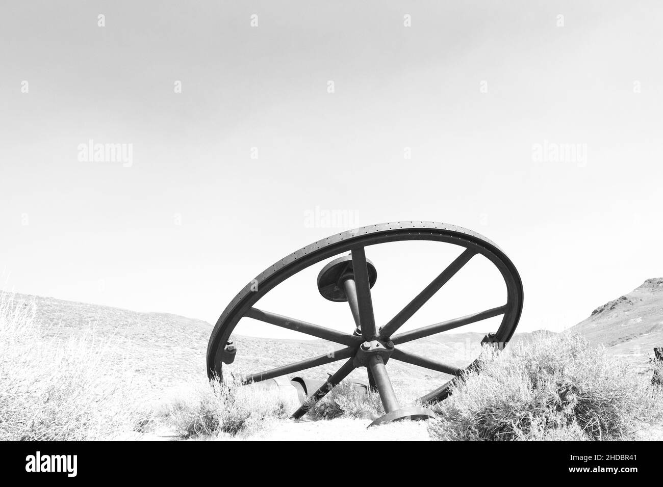 Rendu noir et blanc de la roue au parc national de Bodie, par une journée sans nuages et beaucoup d'espace de copie.Bodie est un fantôme de l'exploitation aurifère de Californie Banque D'Images