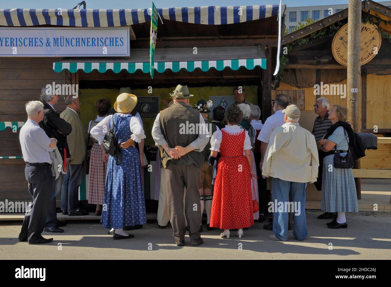 Groupe de personnes en costume traditionnel devant le stand avec bavarois, Oktoberfest, Munich, Bavière, Allemagne Banque D'Images