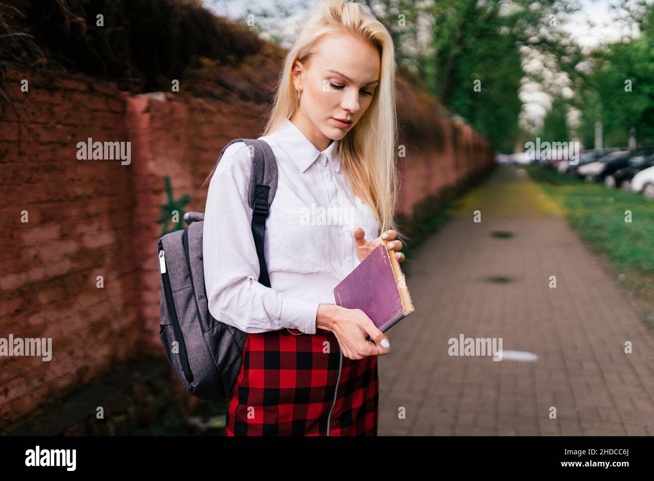 femme dans la rue examine un livre Banque D'Images