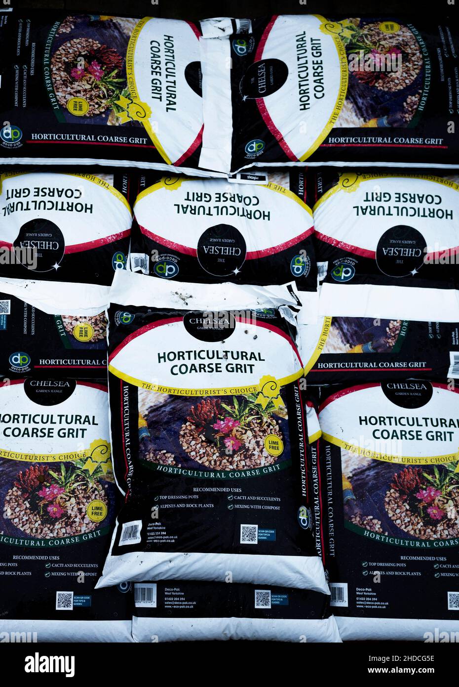 Une pile de sacs de gros grain horticole pour la plantation de pots de vinaigrette et l'amélioration du drainage dans les sols lourds, à vendre dans un centre de jardin Banque D'Images