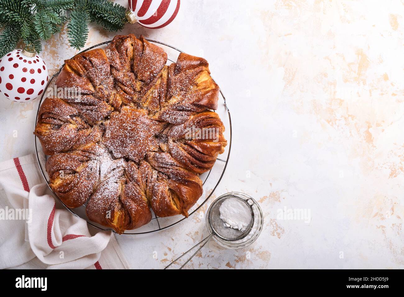 Une étoile de Noël tressée au chocolat et au pain à la cannelle sur une table en bois blanc.Copier l'espace pour le texte.Vue de dessus Banque D'Images