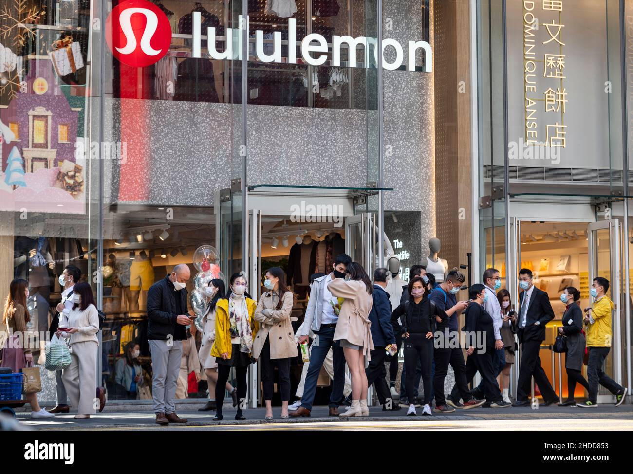 Des piétons marchent devant la bande canadienne de vêtements de sport, magasin Lululemon à Hong Kong. Banque D'Images