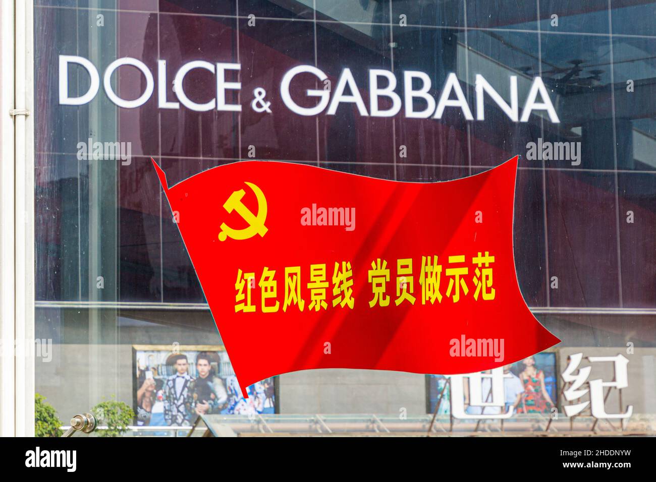 XI'AN, CHINE - 3 AOÛT 2018 : étiquette Dolce et Gabbana derrière un drapeau de marteau et de faucille à Xi'an, Chine Banque D'Images