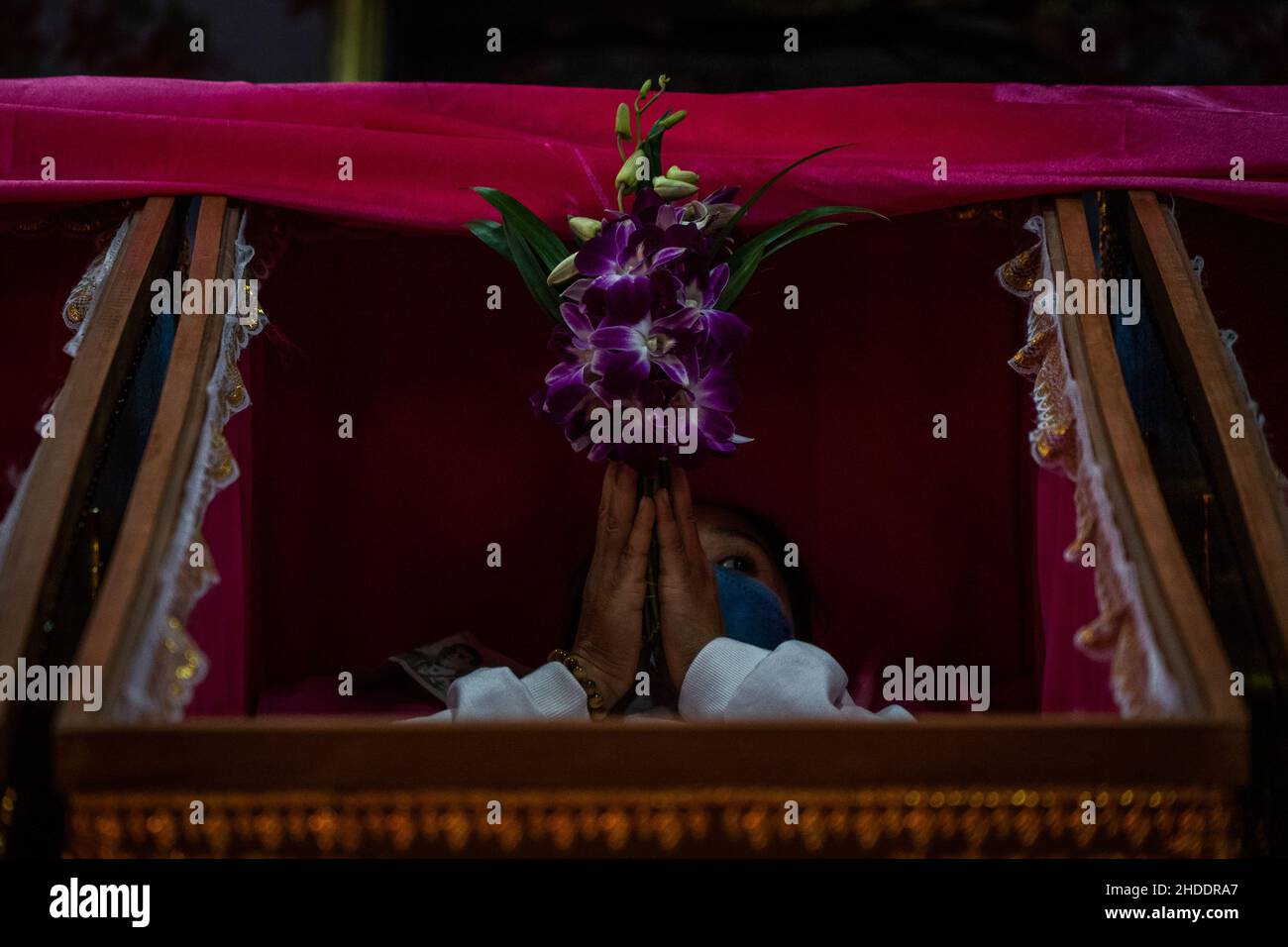 Bangkok, Thaïlande.31st décembre 2021.La femme thaïlandaise s'établit dans un cercueil pendant le rituel de résurrection au temple.les dévotés sont ressuscités dans un rituel annuel du nouvel an au Wat Takien près de Nonthaburi.Ce rite commence par une prière suivie par les participants qui chantent avec des fils saints enveloppés autour de leur tête avant de s'allonger dans un cercueil pour « mourir » et être nettoyés.Crédit : SOPA Images Limited/Alamy Live News Banque D'Images