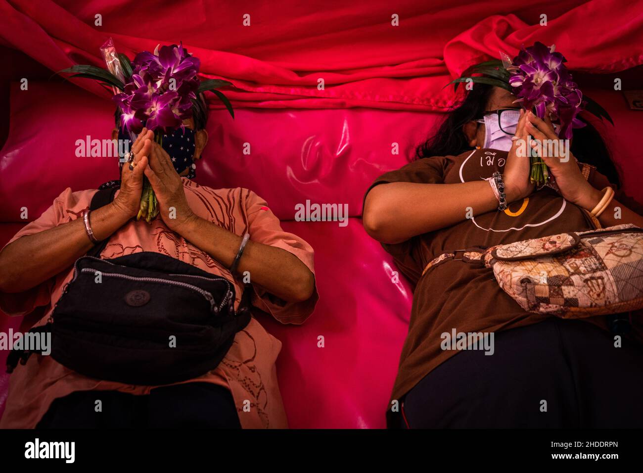 Bangkok, Thaïlande.31st décembre 2021.Les femmes thaïes ont couché et prient dans un cercueil pendant le rituel de résurrection au temple.les dévotés sont ressuscités dans un rituel annuel du nouvel an à Wat Takien près de Nonthaburi.Ce rite commence par une prière suivie par les participants qui chantent avec des fils saints enveloppés autour de leur tête avant de s'allonger dans un cercueil pour « mourir » et être nettoyés.(Photo par Matt Hunt/SOPA Images/Sipa USA) crédit: SIPA USA/Alay Live News Banque D'Images