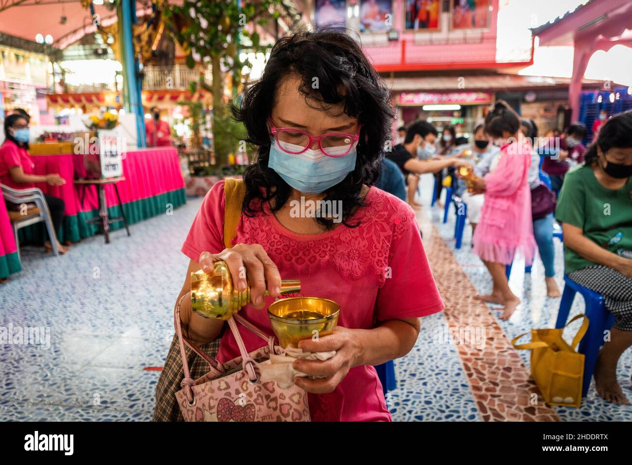 Bangkok, Thaïlande.31st décembre 2021.La femme thaïlandaise verse de l'eau dans une tasse avant de poser dans un cercueil pendant le rituel de résurrection au temple.les dévotés sont ressuscités dans un rituel annuel du nouvel an à Wat Takien près de Nonthaburi.Ce rite commence par une prière suivie par les participants qui chantent avec des fils saints enveloppés autour de leur tête avant de s'allonger dans un cercueil pour « mourir » et être nettoyés.(Photo par Matt Hunt/SOPA Images/Sipa USA) crédit: SIPA USA/Alay Live News Banque D'Images