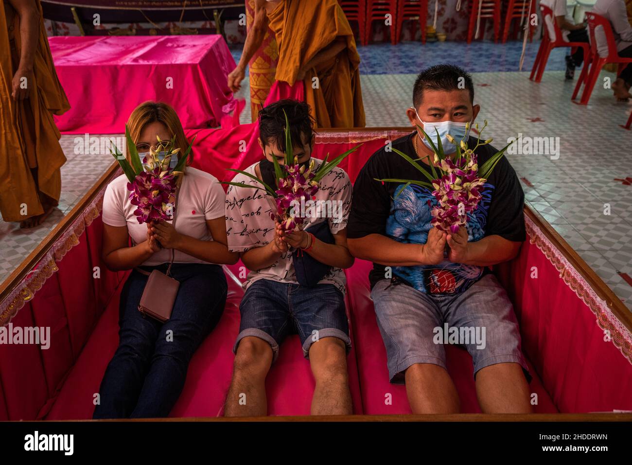 Bangkok, Thaïlande.31st décembre 2021.La famille thaïlandaise s'assoit pour prier après s'être posée dans un cercueil pendant le rituel de résurrection au temple.les dévotés sont ressuscités dans un rituel annuel du nouvel an à Wat Takien près de Nonthaburi.Ce rite commence par une prière suivie par les participants qui chantent avec des fils saints enveloppés autour de leur tête avant de s'allonger dans un cercueil pour « mourir » et être nettoyés.(Photo par Matt Hunt/SOPA Images/Sipa USA) crédit: SIPA USA/Alay Live News Banque D'Images