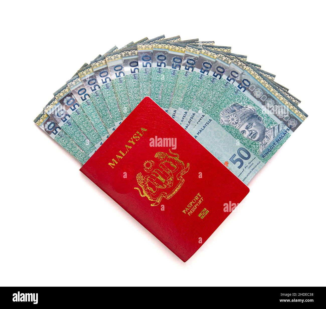 Passeport rouge malaisien avec ringgit malaisien dessous, isolé sur fond blanc. Banque D'Images