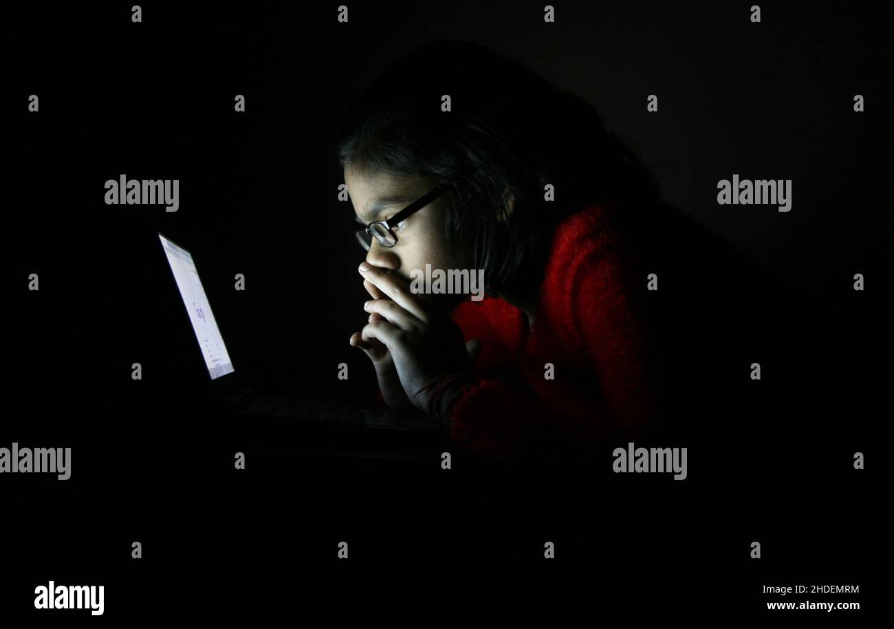 Une fille indienne utilise un ordinateur portable et Internet chez elle à New Delhi, en Inde. Banque D'Images