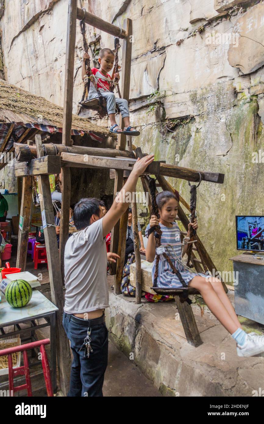 WULINGYUAN, CHINE - 9 AOÛT 2018 : les enfants apprécient la roue de plaisir en bois dans la zone d'intérêt touristique et historique de Wulingyuan dans les forêts nationales de Zhangjiajie Banque D'Images