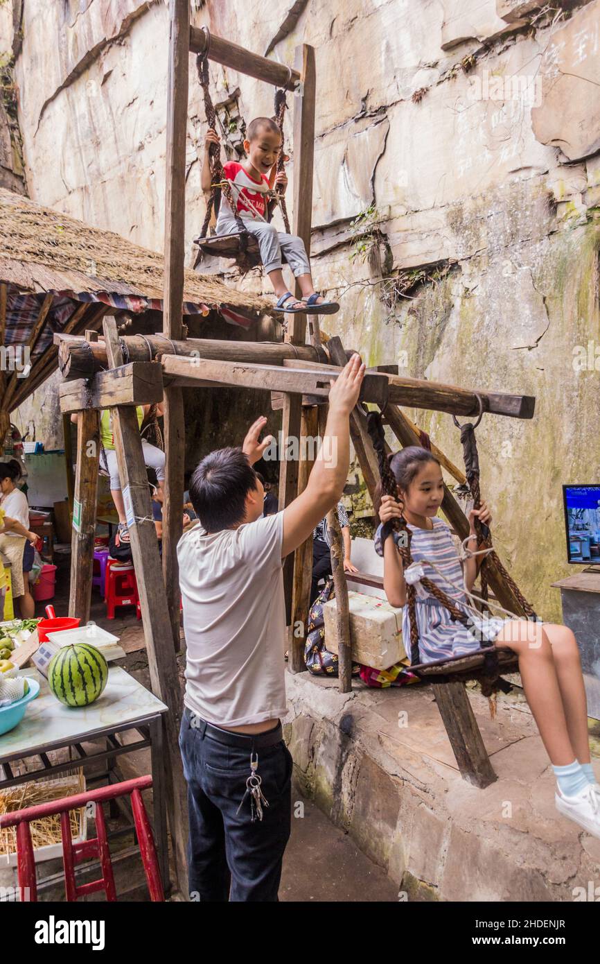 WULINGYUAN, CHINE - 9 AOÛT 2018 : les enfants apprécient la roue de plaisir en bois dans la zone d'intérêt touristique et historique de Wulingyuan dans les forêts nationales de Zhangjiajie Banque D'Images