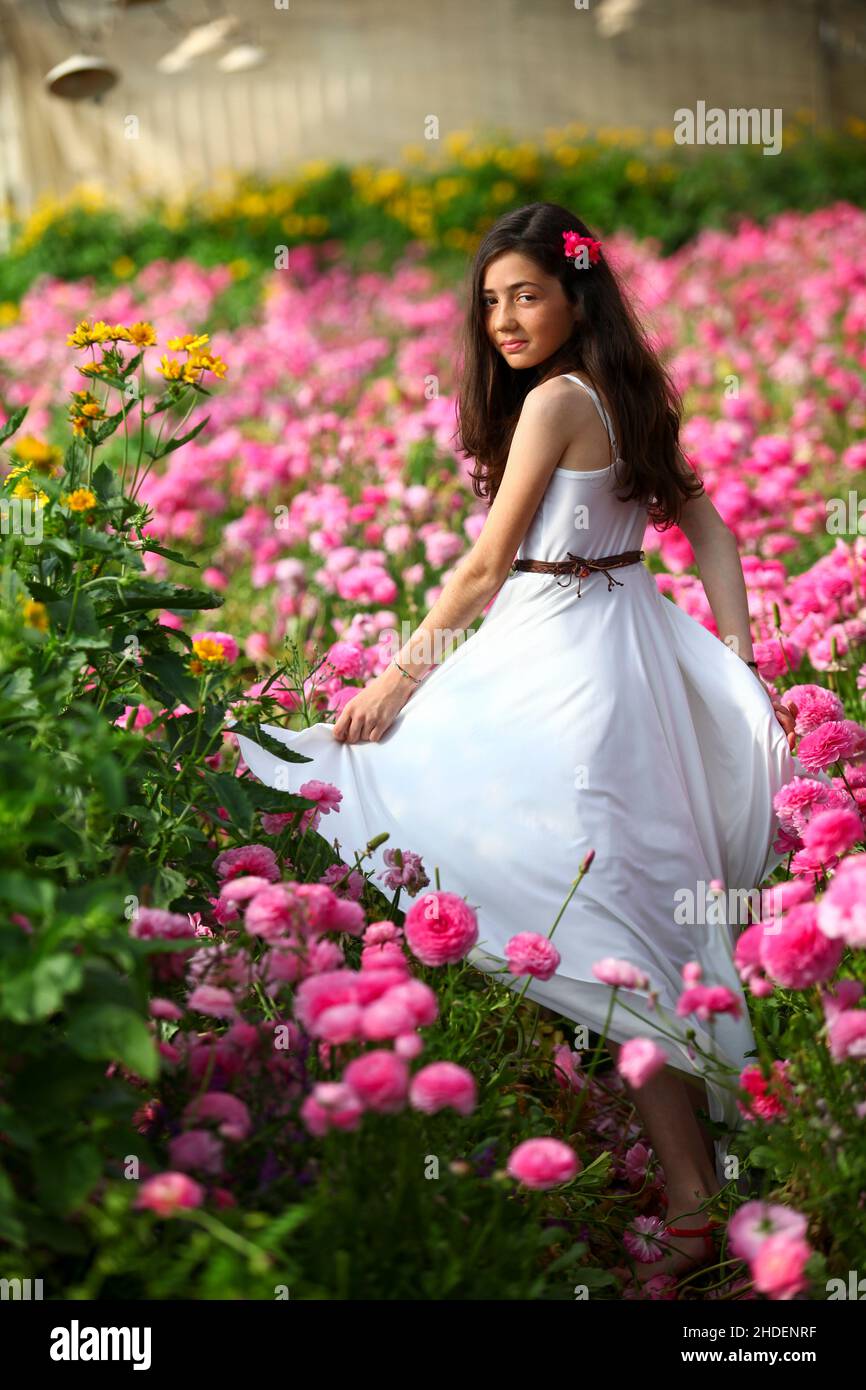 Jeune fille de 12 ans en robe blanche dans une serre de fleurs roses Photo  Stock - Alamy