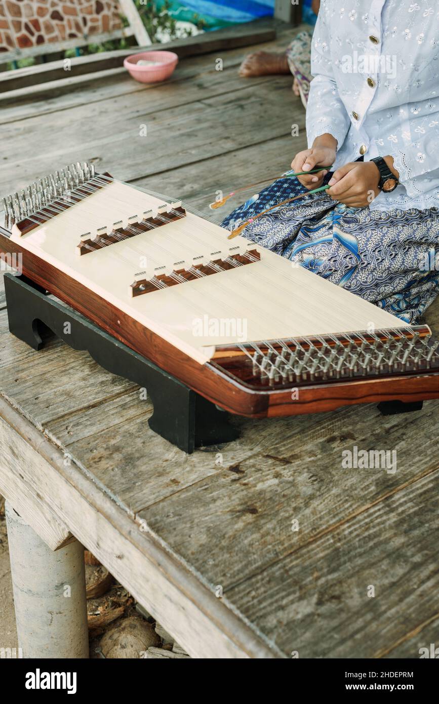 Fille thaïlandaise jouant Khim, l'instrument de musique thaï traditionnel.Concept loisir et passe-temps.Méditation en écoutant de la musique. Banque D'Images