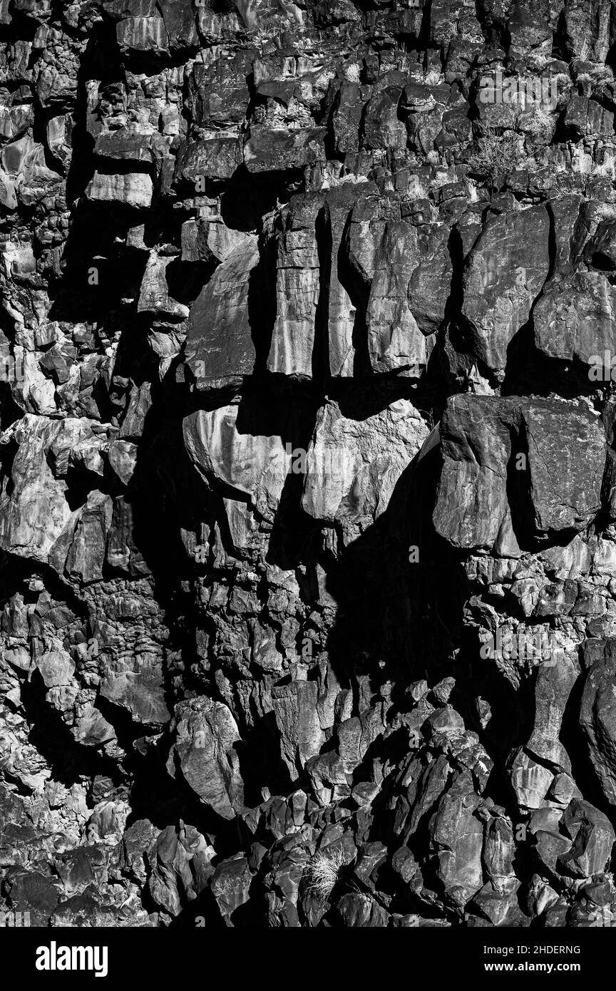 Gros plan en noir et blanc de vieilles roches anciennes sur un mur Banque D'Images