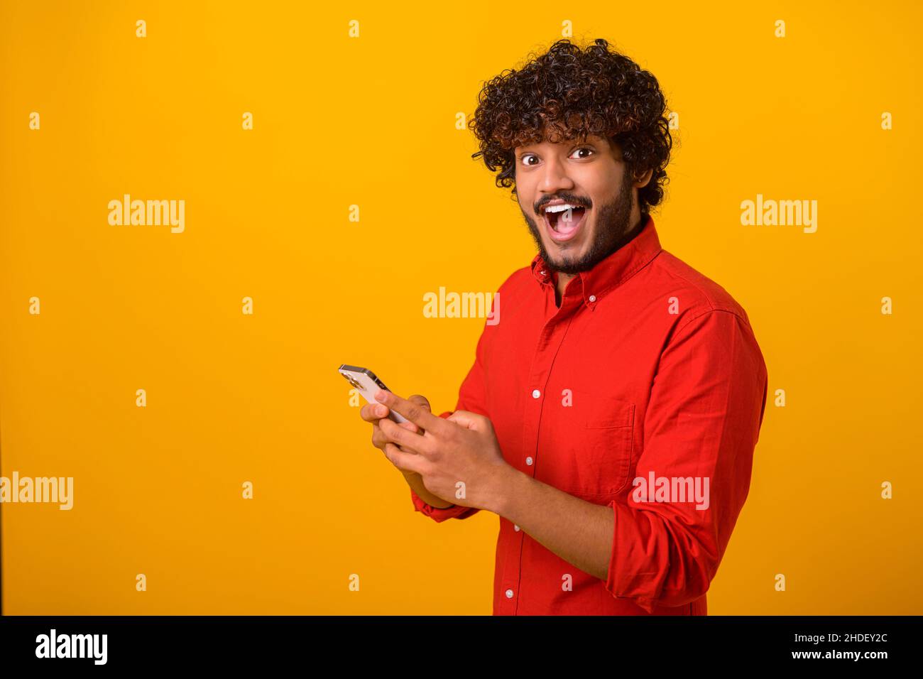 Drôle surpris gars branché soudainement lire le message sur son téléphone mobile et exprimant l'étonnement de choc, des nouvelles incroyables sur smartphone.Studio tourné isolé Banque D'Images