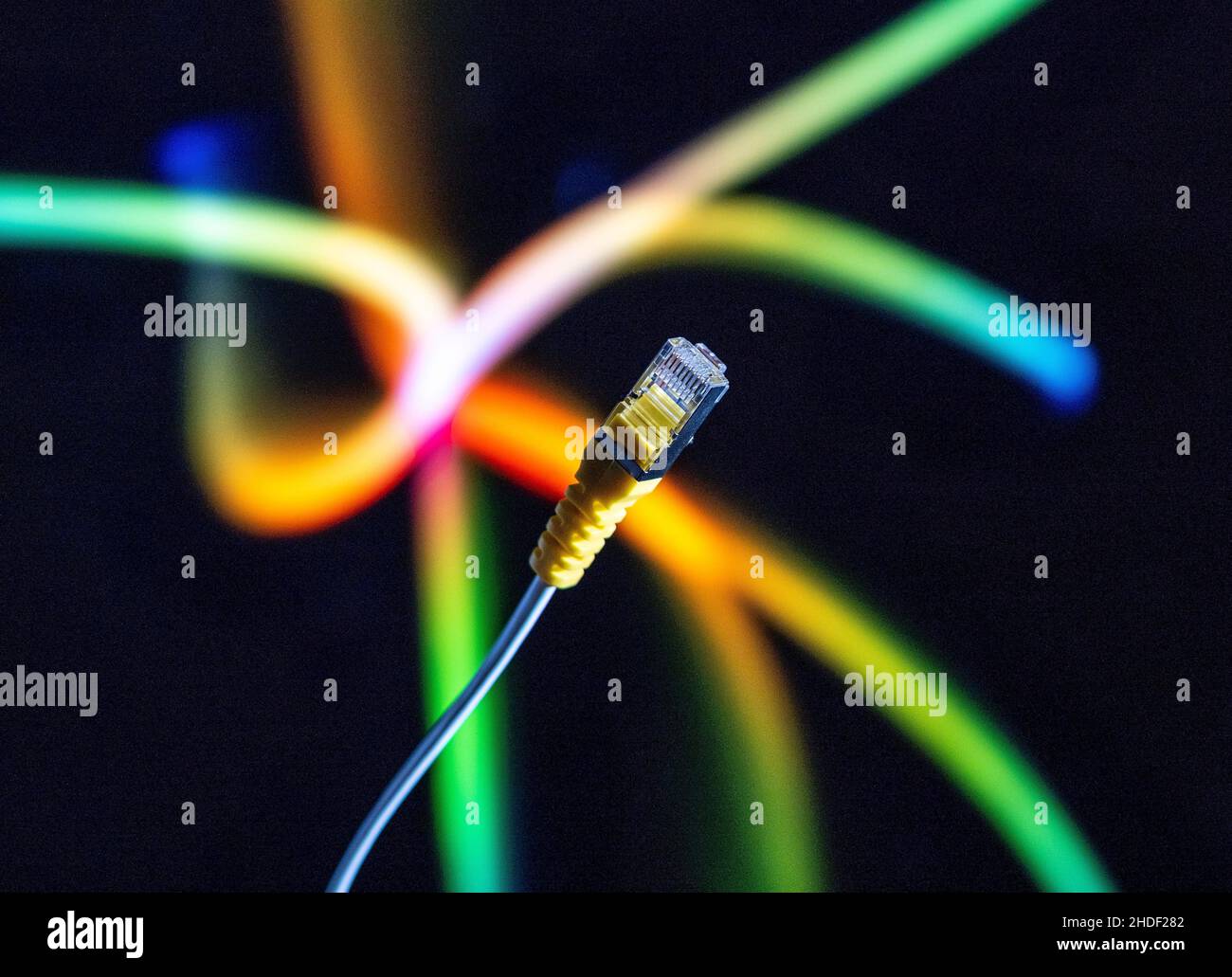 Câble Internet et connecteur ethernet jaune en gros plan sur un arrière-plan coloré. Banque D'Images