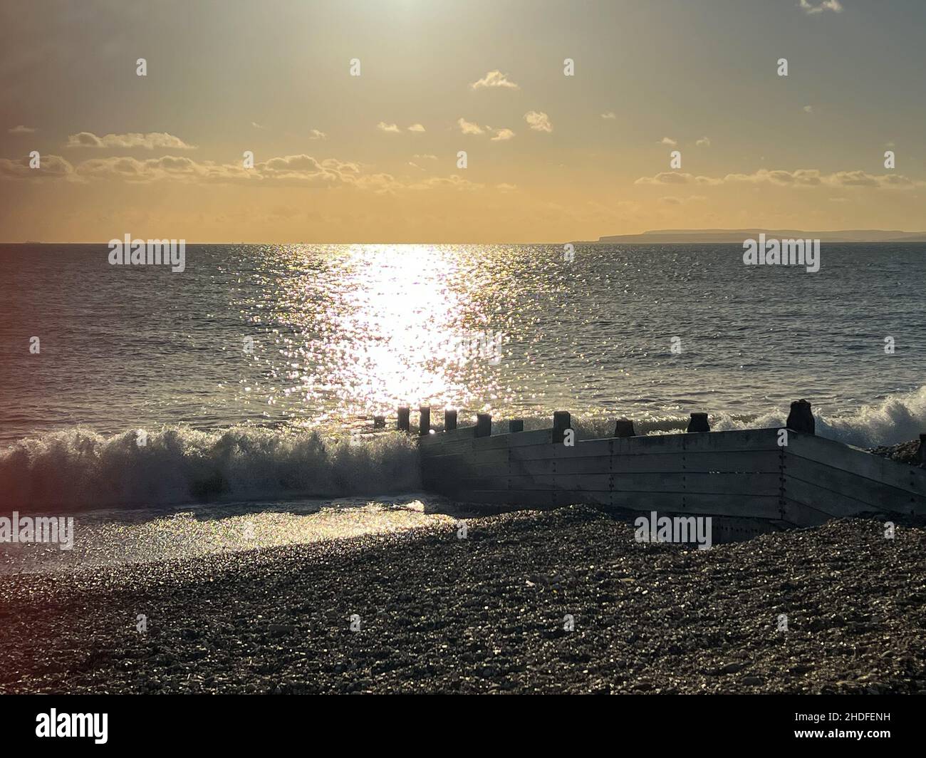 La lumière du soleil se réfléchit sur la mer tandis que les vagues se délatent sur la plage de Hayling Island, Hampshire, Royaume-Uni Banque D'Images
