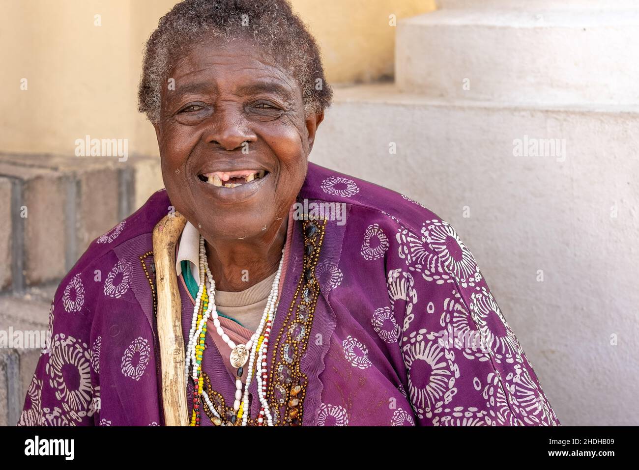 Portrait d'une femme afro-caribéenne souriant à l'appareil photo bien que sa santé dentaire ne soit pas bonne.Elle porte divers colliers de la 'santeria' religii Banque D'Images