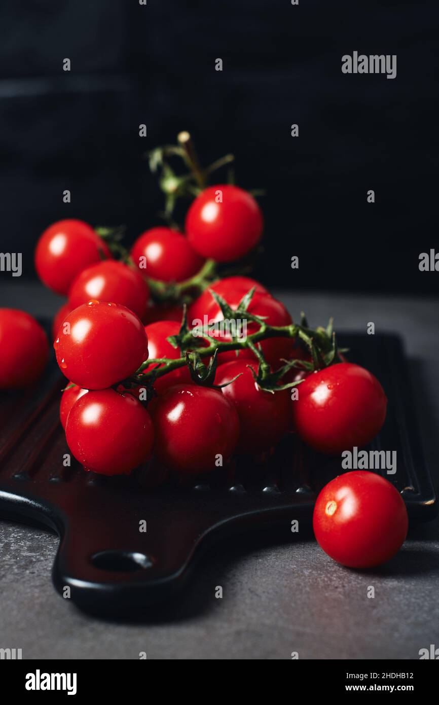 Tomates cerises rouges fraîches sur la vigne. Banque D'Images