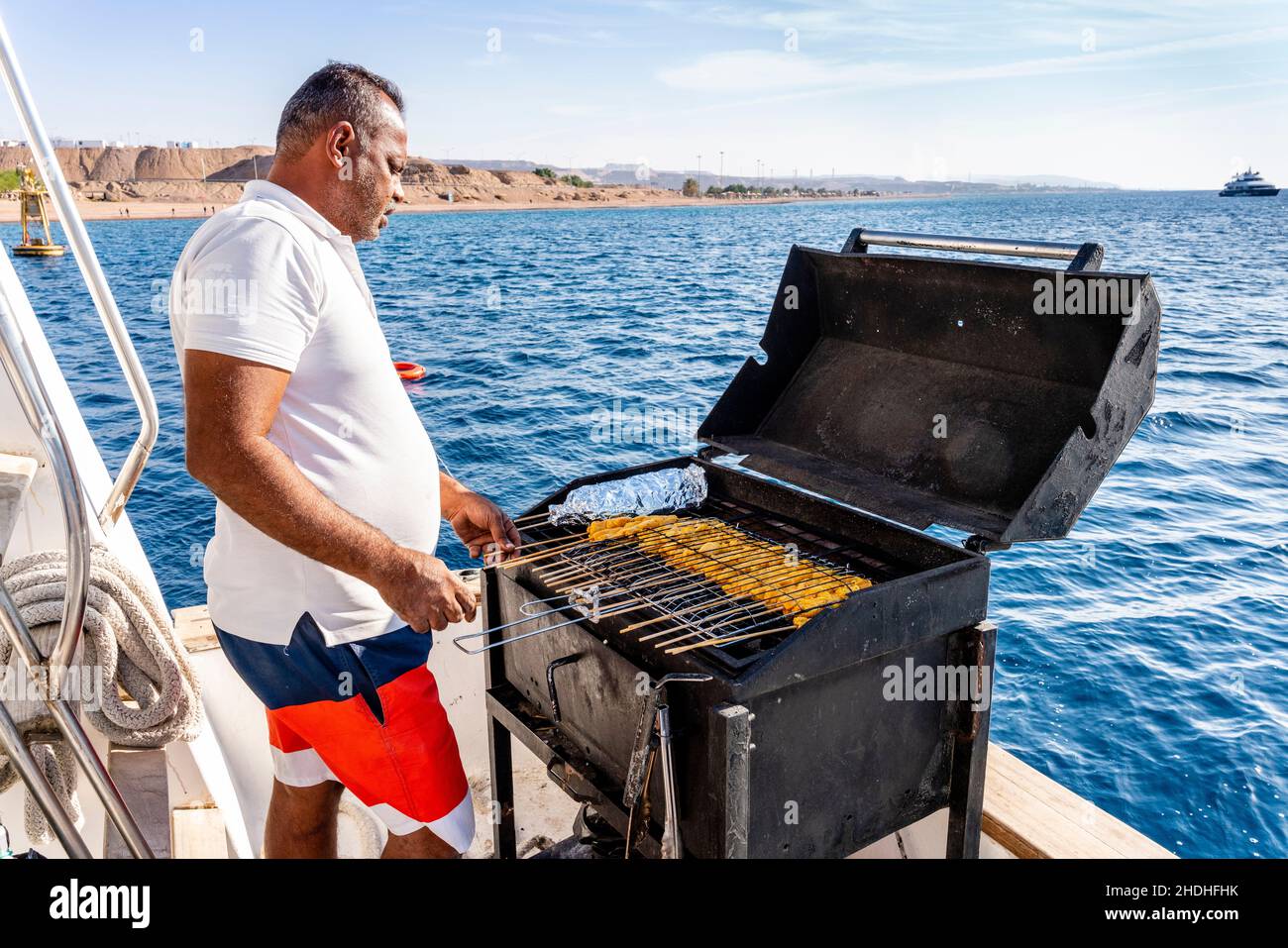 Un homme cuisinera la nourriture de barbecue à bord D'Un bateau touristique  sur la mer Rouge, Aqaba, Aqaba Governorat, Jordanie Photo Stock - Alamy
