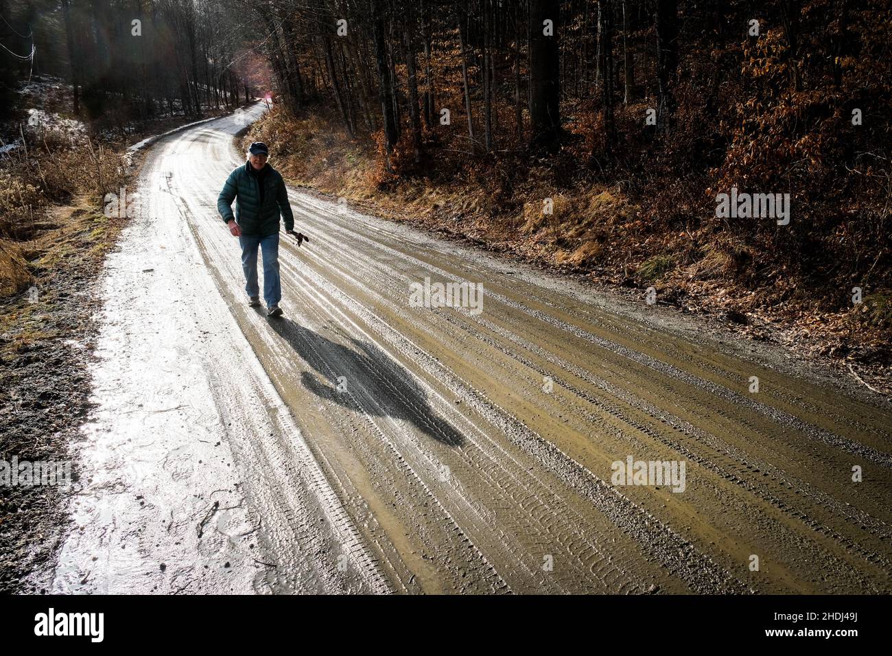 Un vieux solitaire marche le long d'une route de terre rurale dans l'est de Montpelier, VT, Nouvelle-Angleterre, Etats-Unis. Banque D'Images