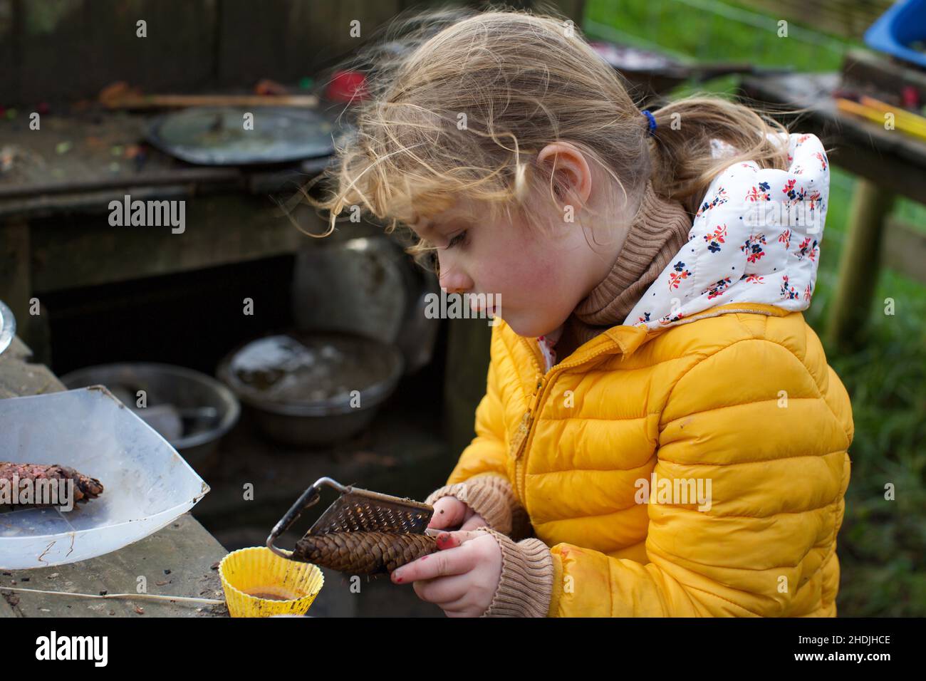 Un enfant de 5 ans jouant à l'extérieur dans une cuisine de boue, Royaume-Uni Banque D'Images