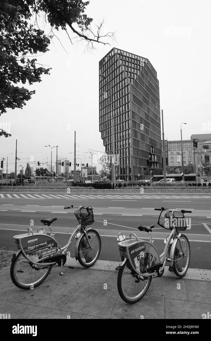 Location de vélos dans une rue avec le bâtiment de bureaux Baltyk. Banque D'Images