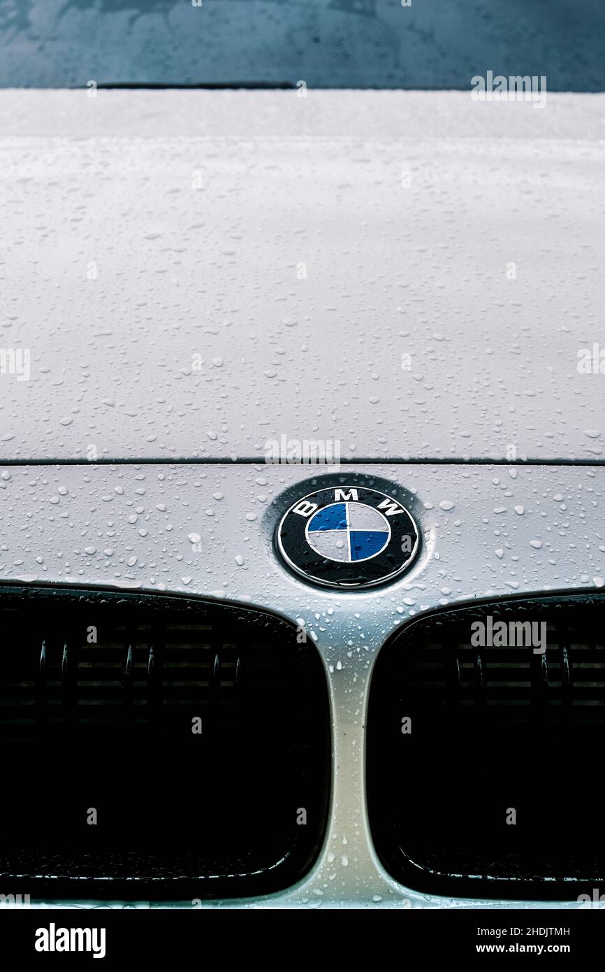 Gros plan du logo BMW sur une capuche blanche BMW 330E avec gouttes de pluie Banque D'Images