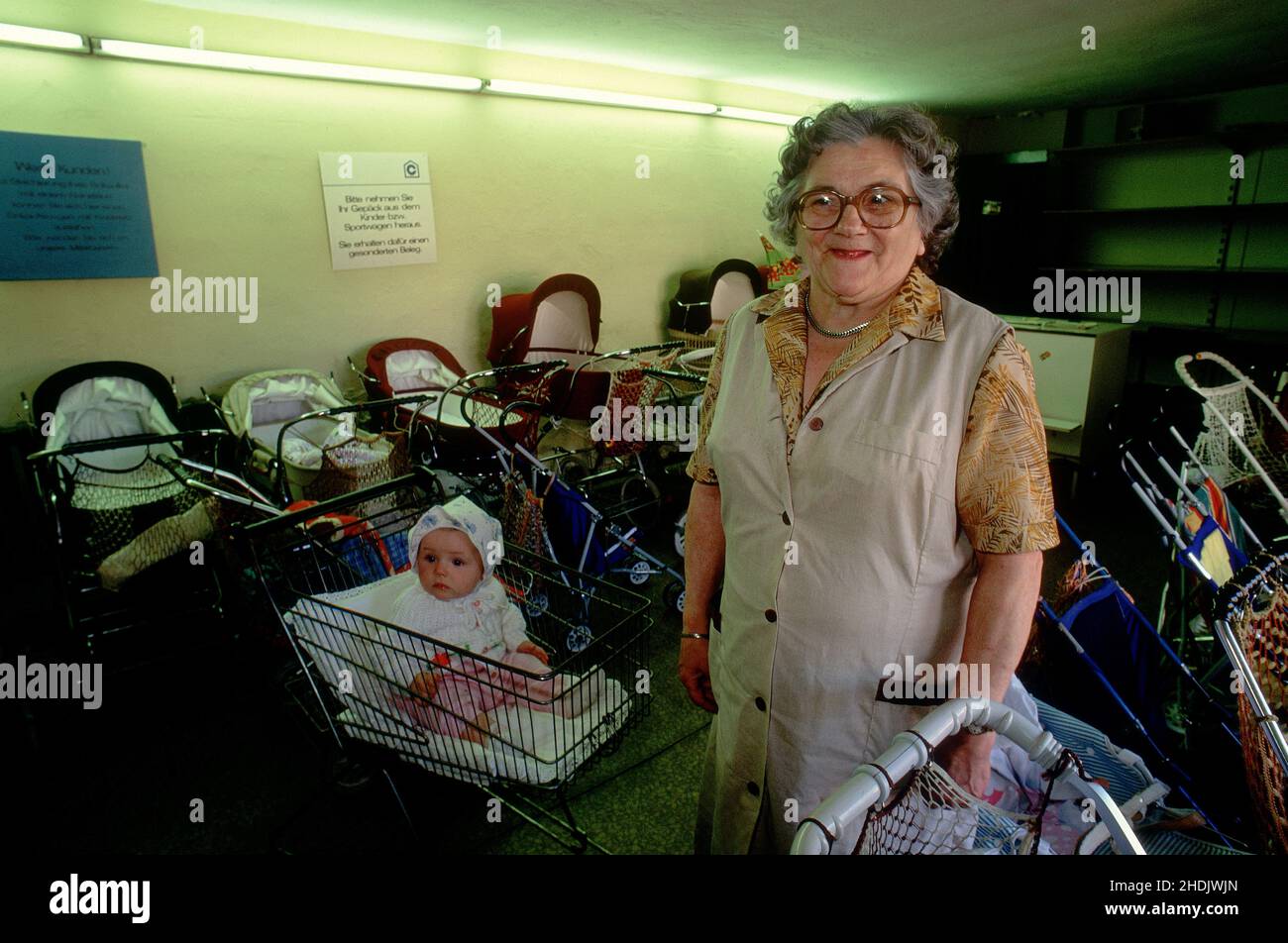 Un enfant assis dans un magasin un travailleur de cart.child soins a mis le tout-petit dans un chariot de magasinage .Allemagne de l'est, Allemagne Banque D'Images