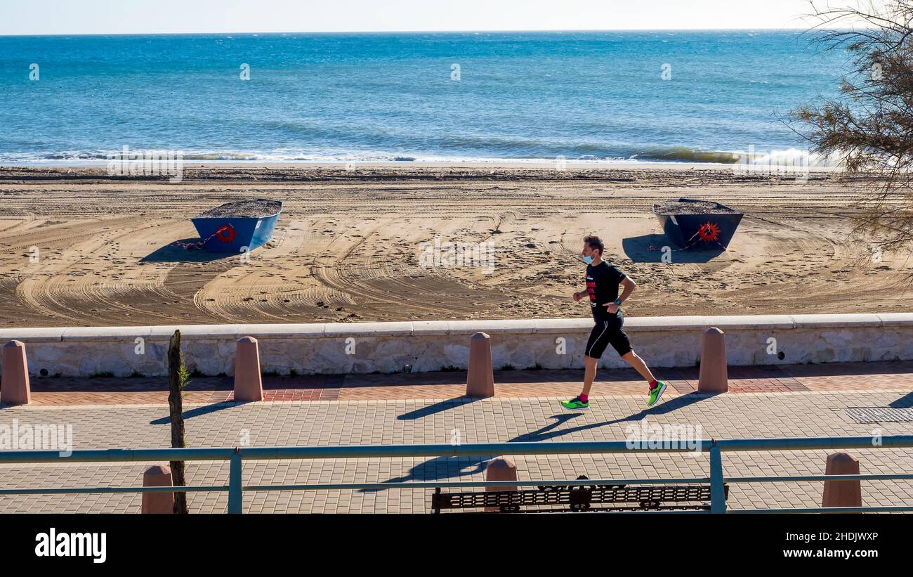 Fuengirola, Malaga, Espagne.02,06,2021 Jeune homme courant le long d'une promenade de Fuengirola en face de la mer par une belle journée d'hiver. Banque D'Images