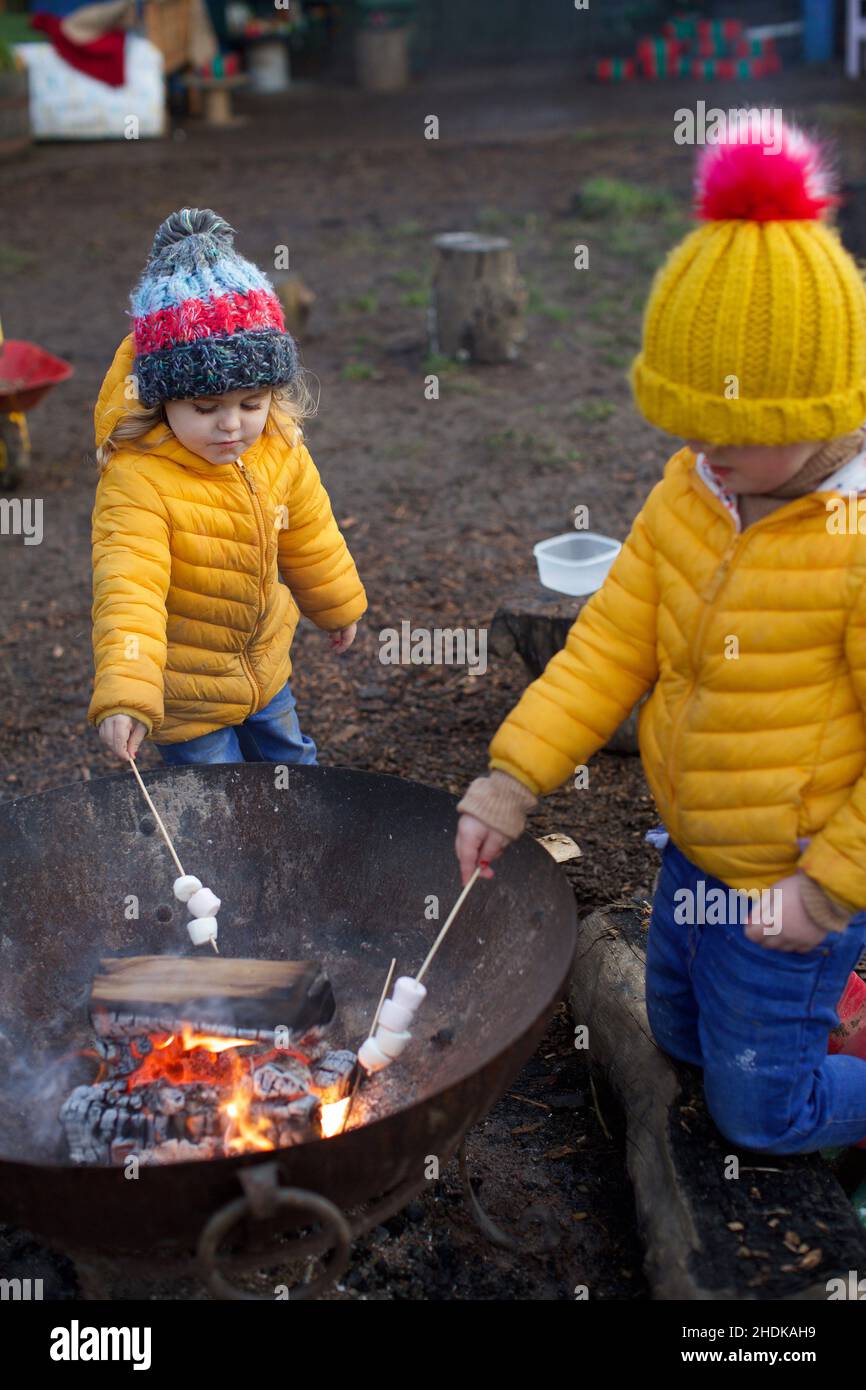 Enfants cuisant des guimauves sur un feu ouvert, Royaume-Uni Banque D'Images
