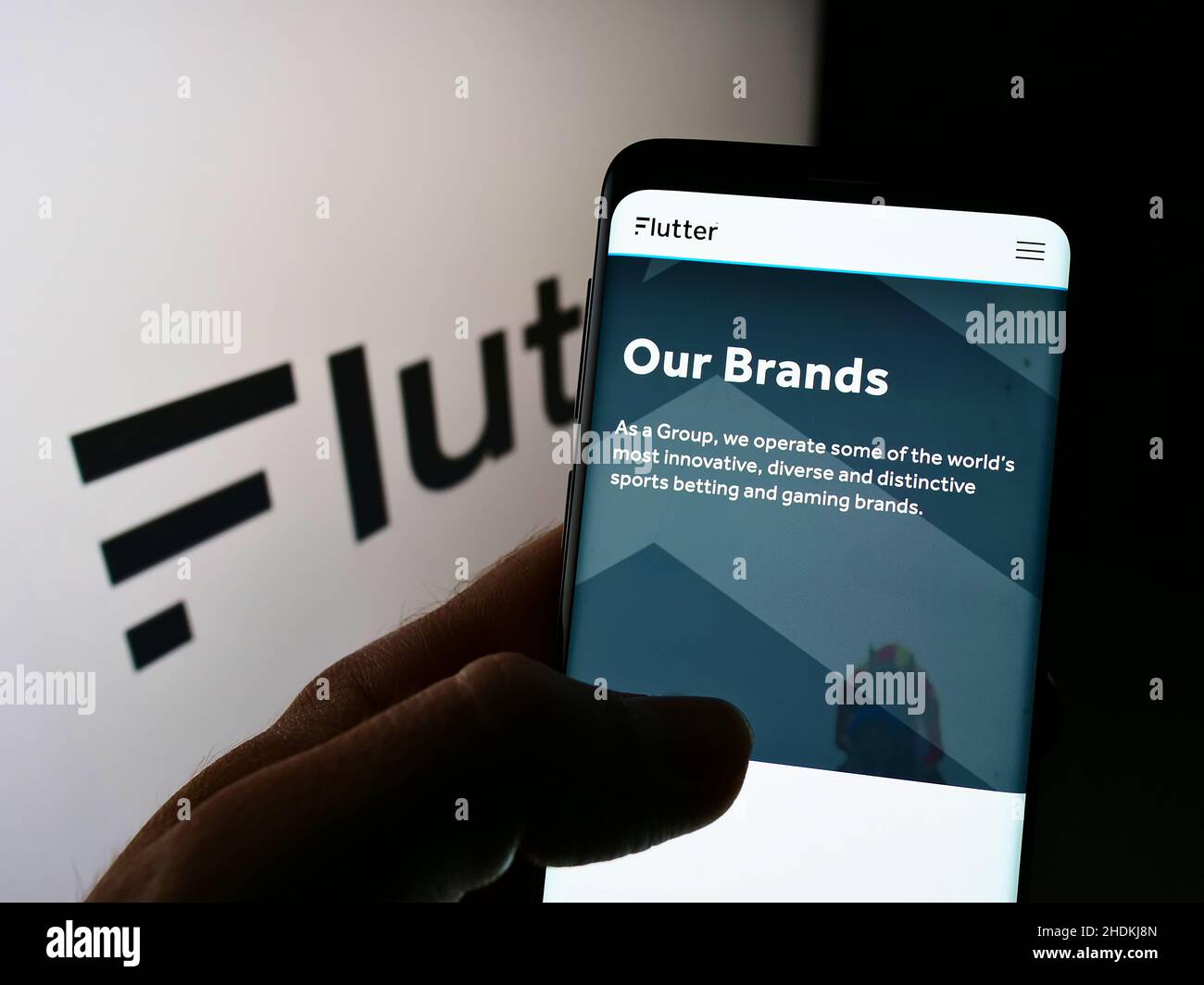 Personne tenant un smartphone avec une page Web de la société irlandaise de bookmaking Flutter Entertainment plc à l'écran avec logo.Concentrez-vous sur le centre de l'écran du téléphone. Banque D'Images