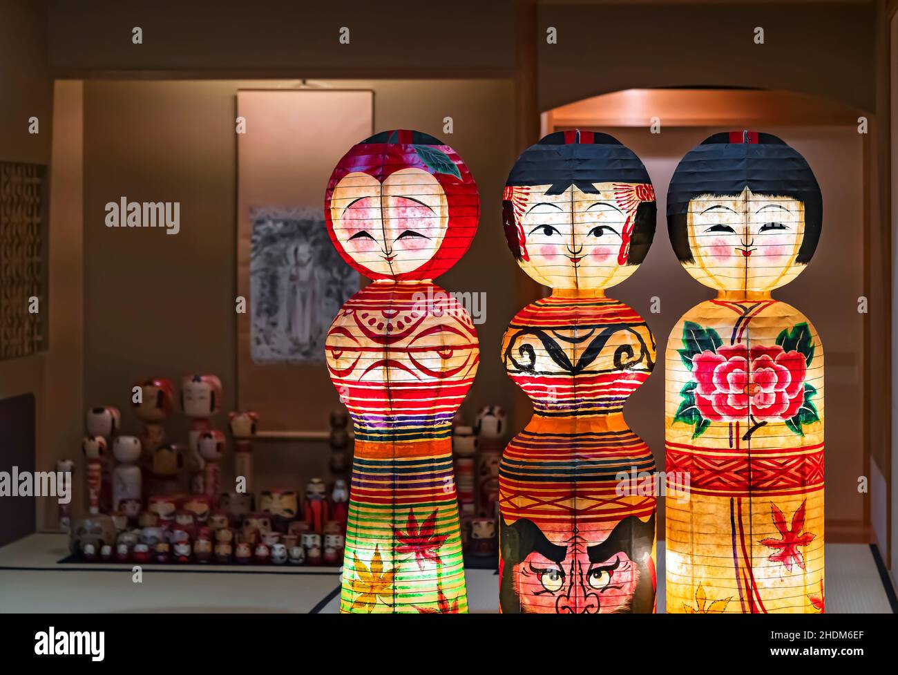 tokyo, japon - octobre 14 2021 : lanternes en papier illuminées représentant des poupées kokeshi traditionnelles japonaises peintes à la main et ornées de feuilles de momiji, daruma fa Banque D'Images