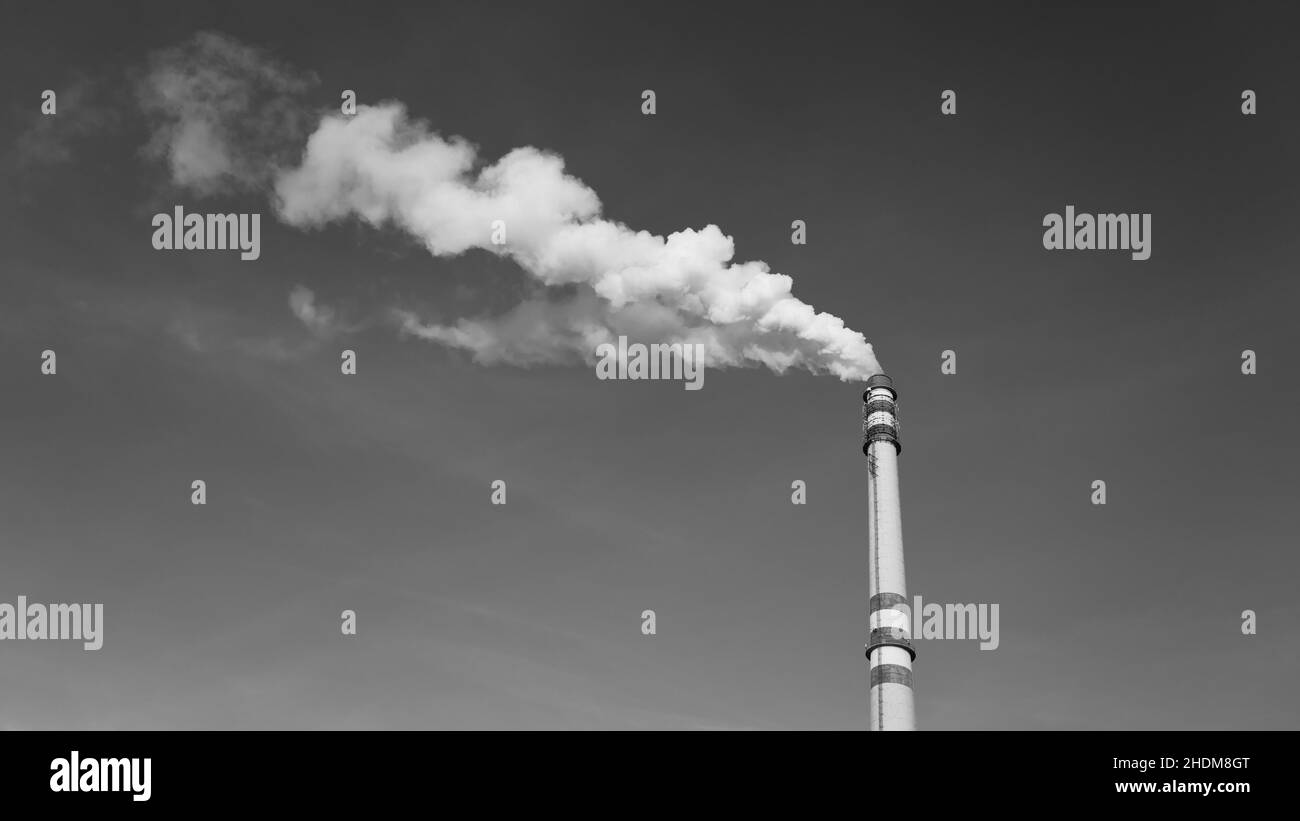 Cheminée industrielle fumant le jour d'hiver ensoleillé Banque D'Images