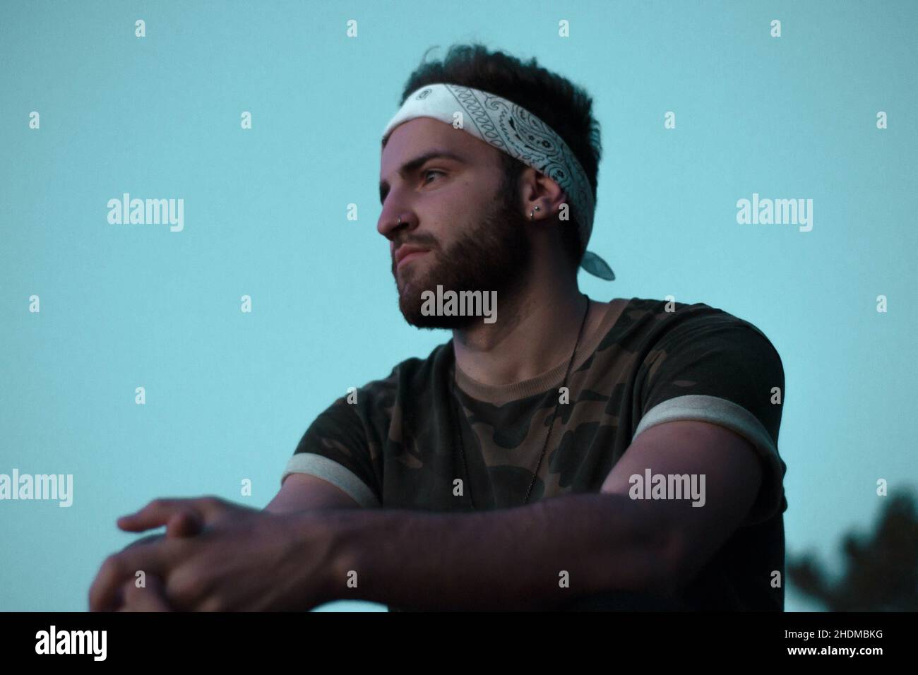 Portrait d'un jeune garçon caucasien avec un t-shirt imprimé militaire sur fond bleu Banque D'Images