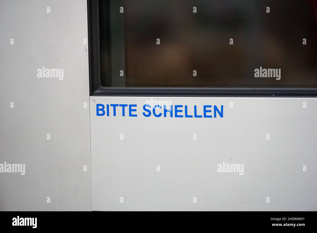 Gros plan du panneau « Please ring » sur une porte vitrée en allemand Banque D'Images