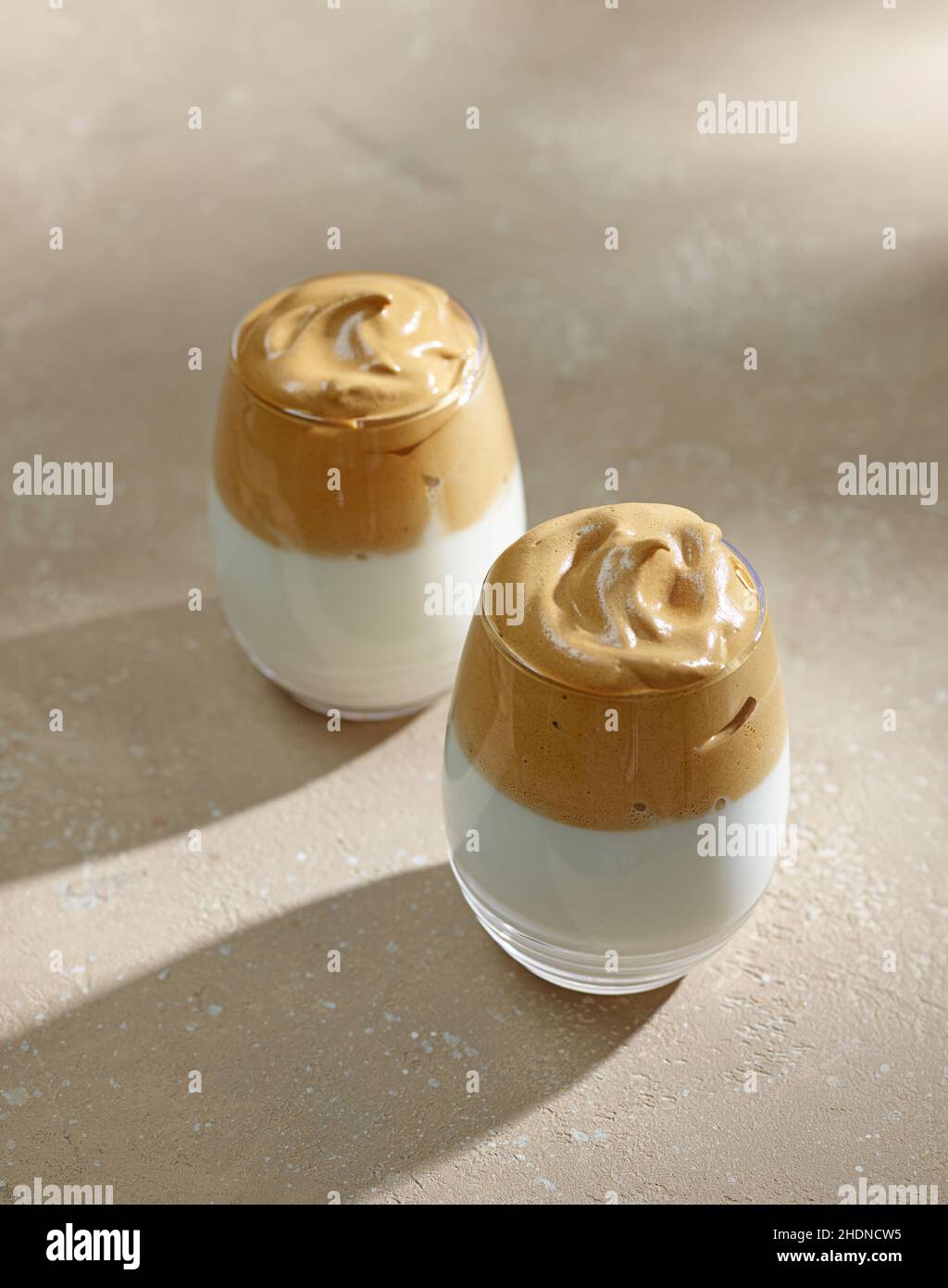 Deux verres de café Dalgona sur fond beige de table de cuisine Banque D'Images